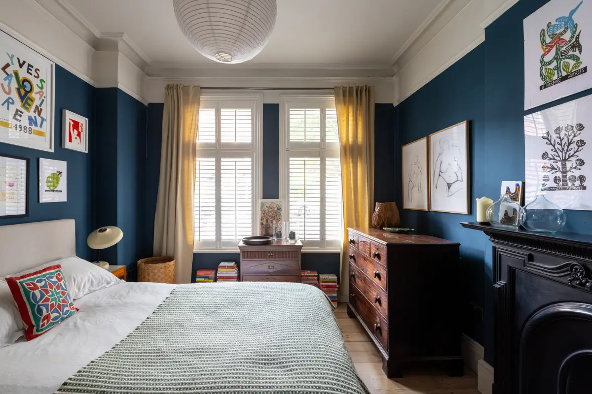 A Modern Extension and Period Details in a Ground Floor London Home 11 blue-bedroom-large-windows-fireplace.webp