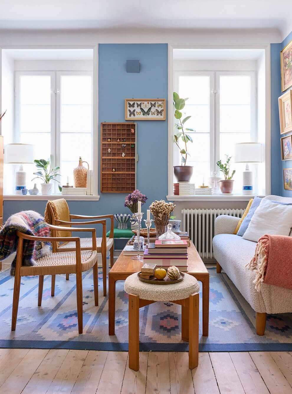 A Blue Living Room Filled with Art in a Swedish Apartment 5 blue sitting room vintage furniture wooden floorboards