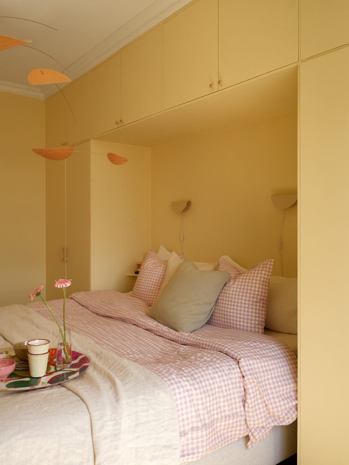 A Stockholm Apartment with a Butter-Yellow Bedroom 17 butter-yellow bedroom wardrobes fitted around the bed