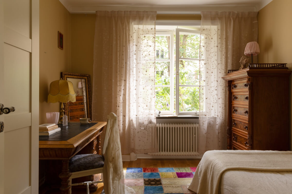 A 1930s Stockholm Apartment With Views of a Lush Garden 15 dark-beige-bedroom-antique-desk