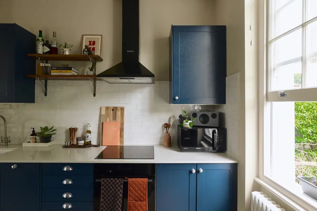 A Classic Victorian Duplex with a Lush, Private Garden in London 12 dark blue kitchen cabinets white backsplash tiles