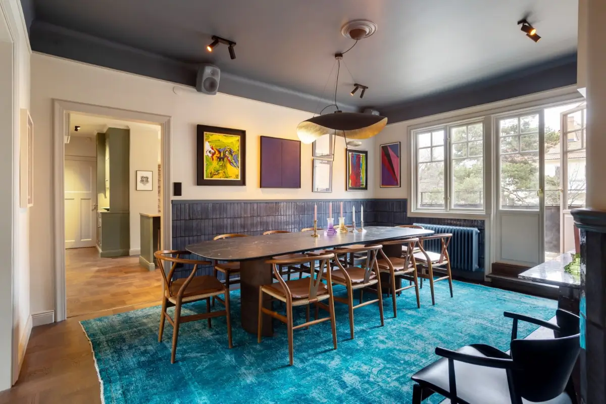 dining room half blue-tiled walls and blue rug under marble-topped table nordroom