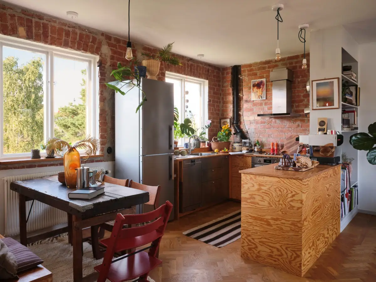 A Pink Bathroom and a Plywood Kitchen in a Stockholm Apartment 1 exposed brick wall wood kitchen herringbone floor