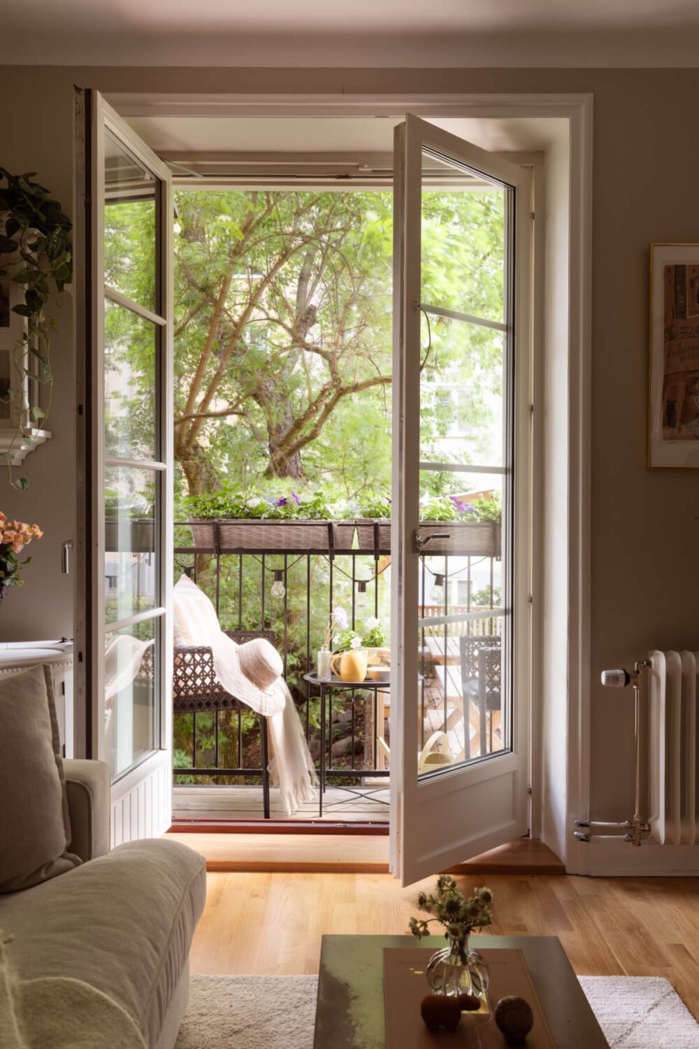 A 1930s Stockholm Apartment With Views of a Lush Garden 3 glass doors to courtyard balcony