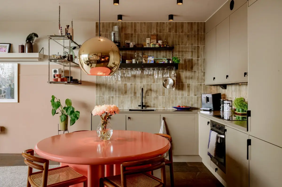 A Modern Swedish Apartment with Half-Painted Pink Walls 9 gray kitchen with round pink dining table