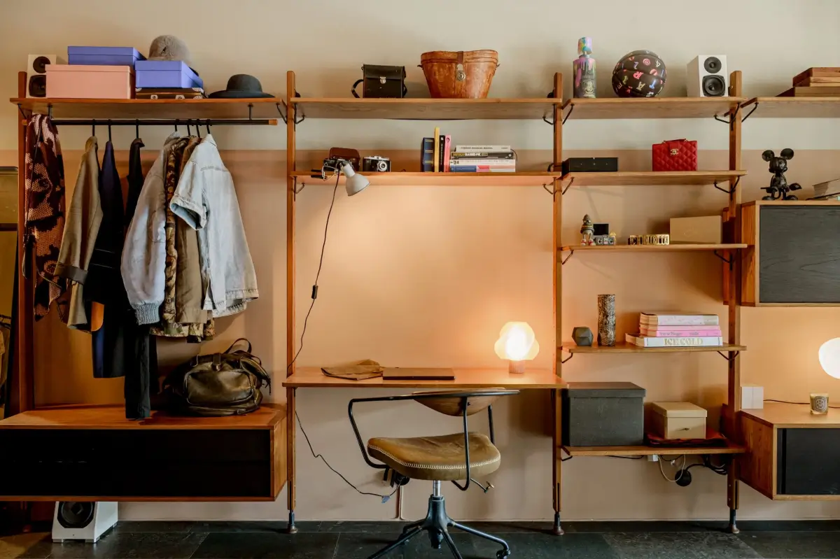 A Modern Swedish Apartment with Half-Painted Pink Walls 13 hall with shelving system with desk and wardrobe space
