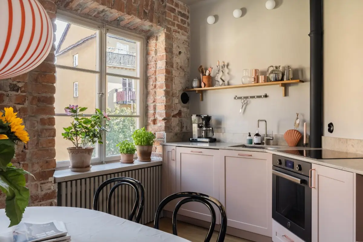 kitchen light pink cabinets exposed brick wall