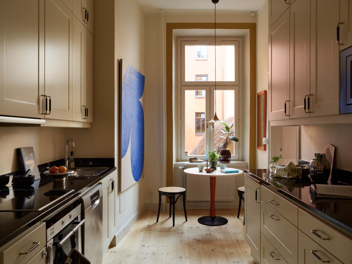 Blue and Red Color Accents in a Stylish Scandinavian Apartment 25 kitchen with small round table