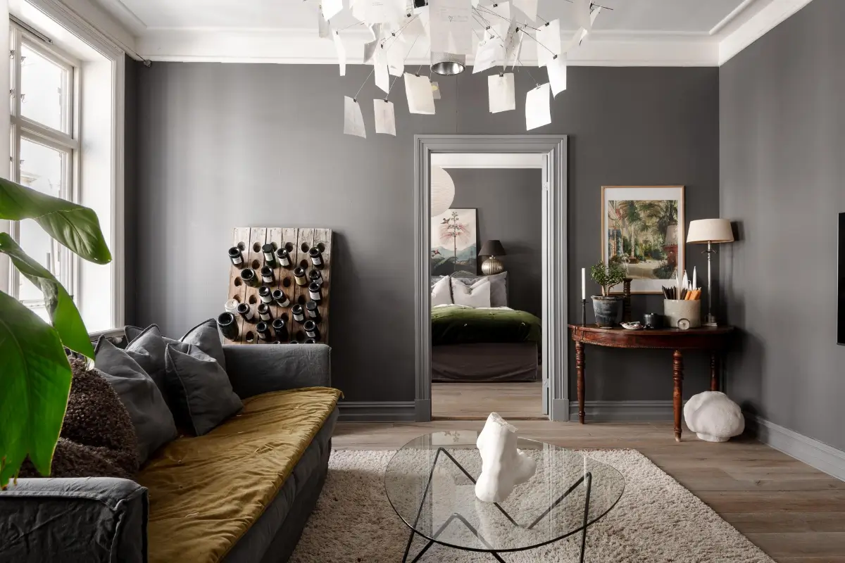 A Dark Gray Swedish Apartment with an Olive Green Kitchen 9 living room gray walls antique side table