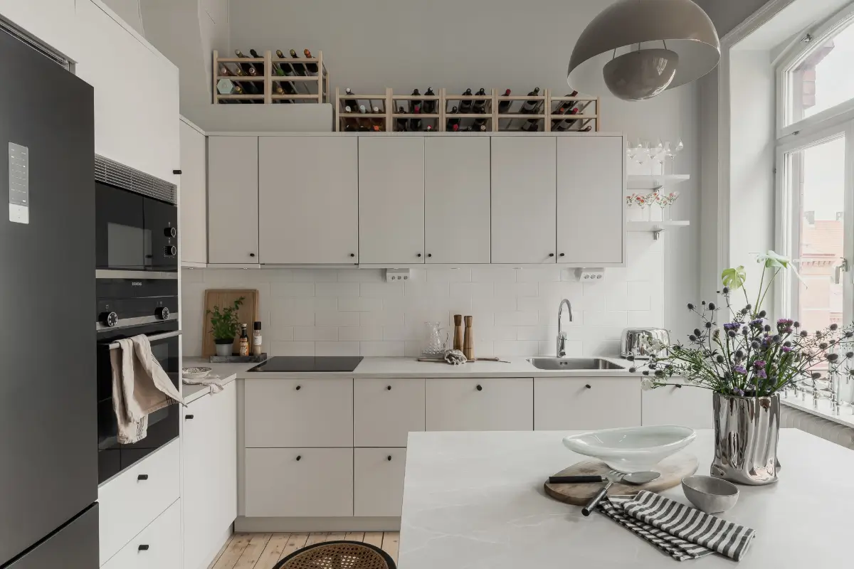 A Gray Scandinavian Apartment with a Royal History 11 modern white kitchen black knobs nordroom