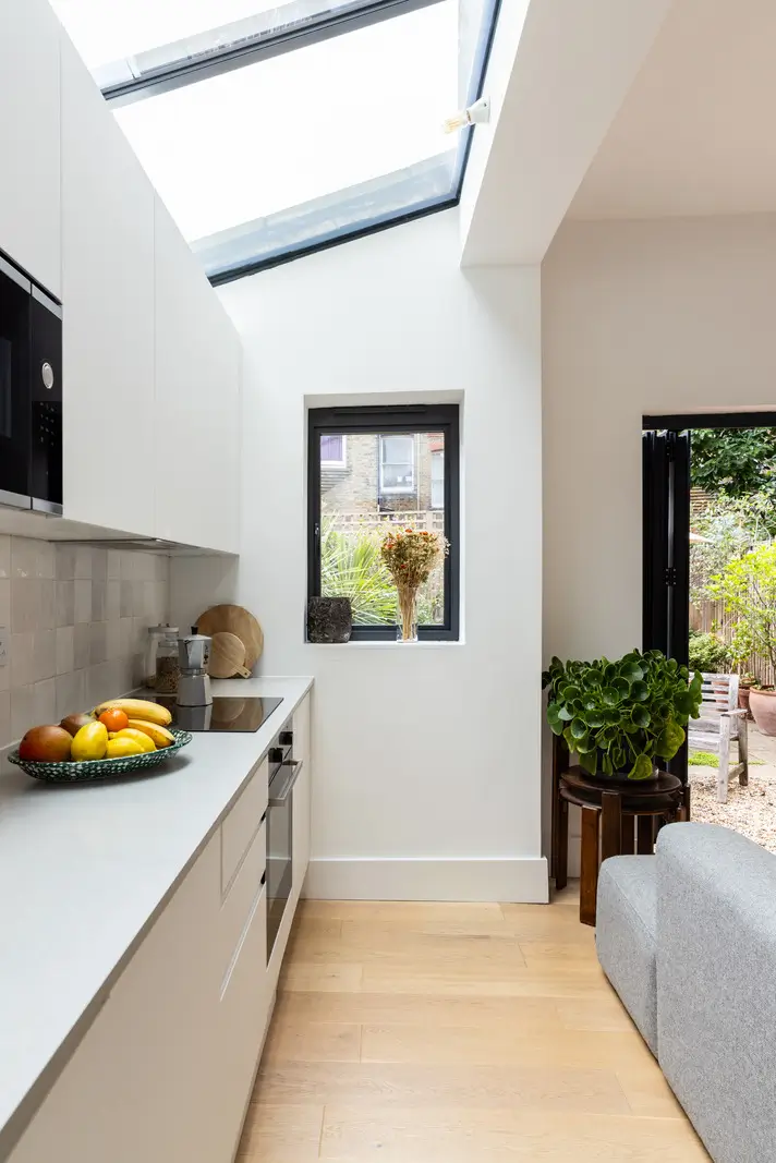 A Modern Extension and Period Details in a Ground Floor London Home 6 modern white kitchen with skylights