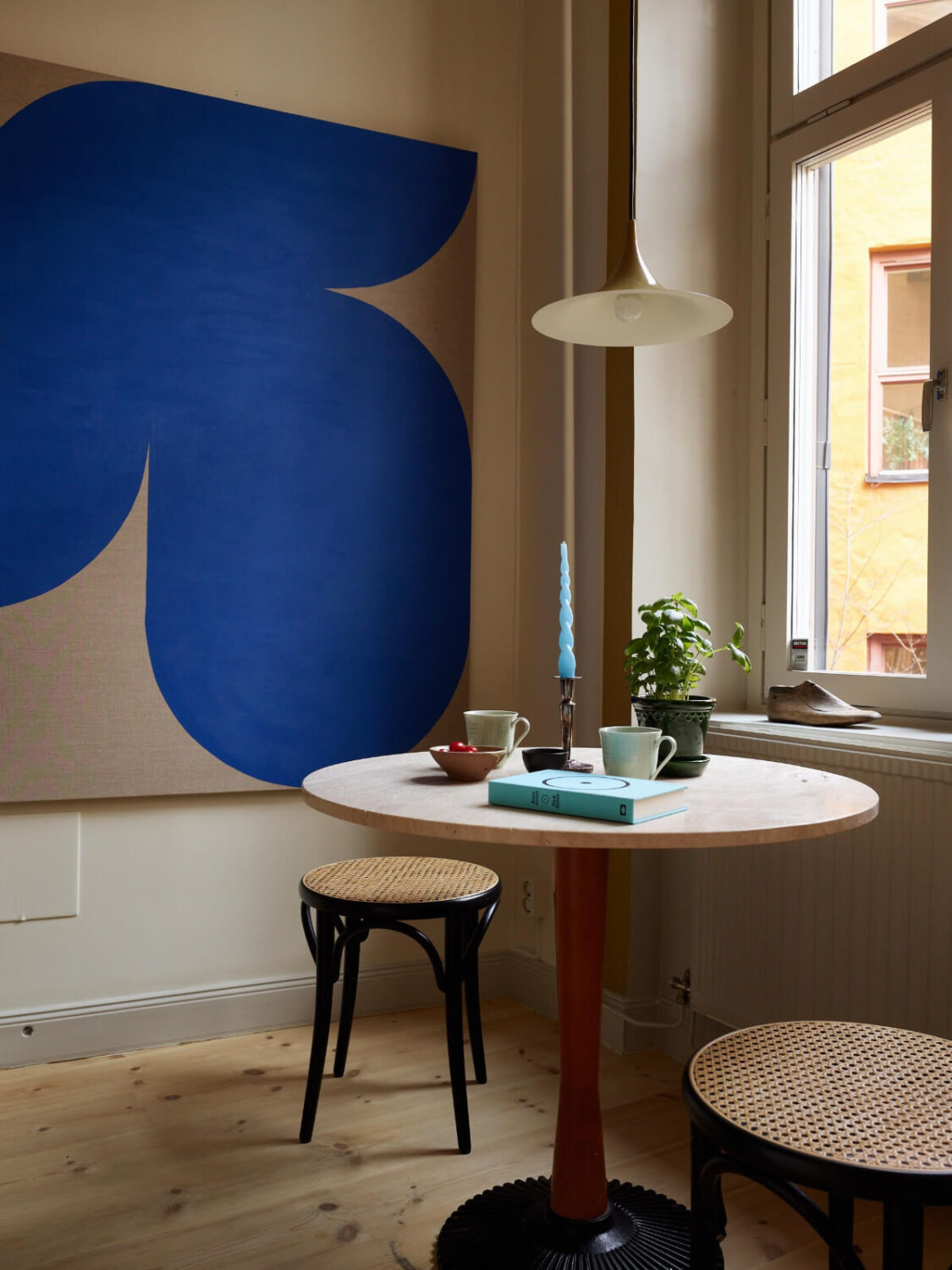 Blue and Red Color Accents in a Stylish Scandinavian Apartment 26 small round kitchen table with stools and large blue art
