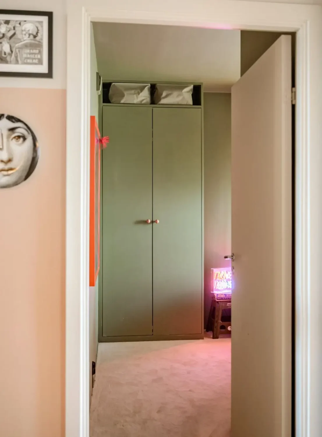 A Modern Swedish Apartment with Half-Painted Pink Walls 19 view into bedroom green wardrobes