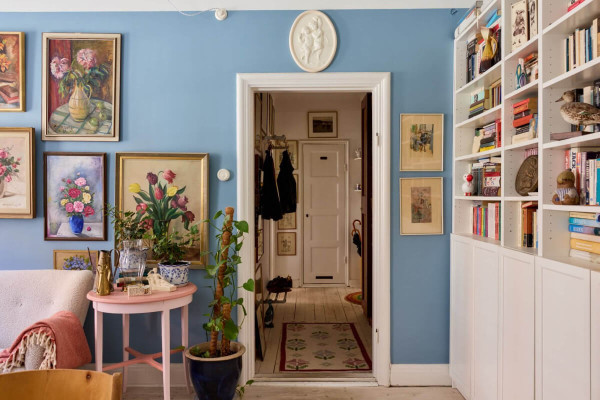 A Blue Living Room Filled with Art in a Swedish Apartment 9 view into hall