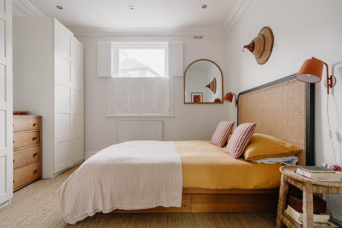 A Modern Ground-Floor Apartment with a Tiny Patio Garden 15 white bedroom cane headboard yellow bedding