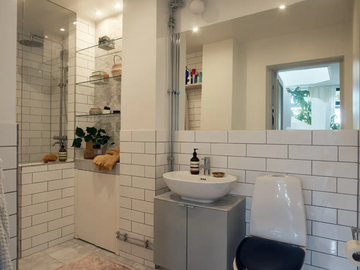 Industrial Elements in a 1960s Duplex Apartment in Stockholm 17 white tiled bathroom glass shelves