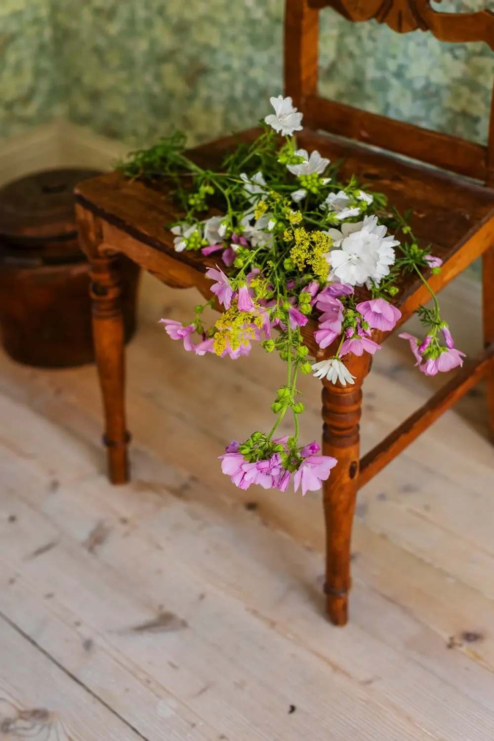 A Historic Lakeside Summer House in the Stockholm Archipelago 9 wooden chair with wildflowers