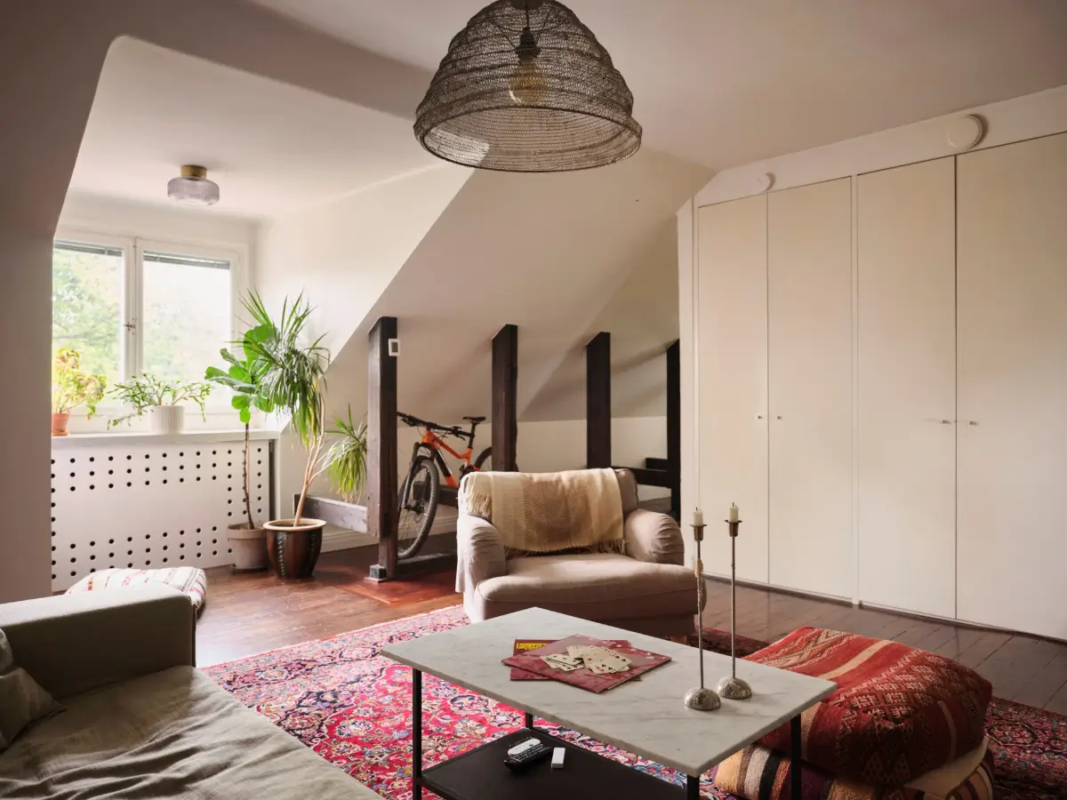 Exposed Beams and Dark-Stained Floorboards in a Cozy Attic Apartment 6 attic living room built-in wardrobes