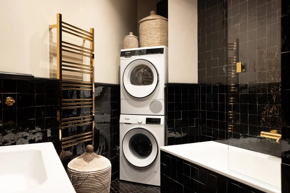 A Luxurious Family Apartment with a Dramatic Black Bathroom 31 bathroom black tiles niche for washer and dryer