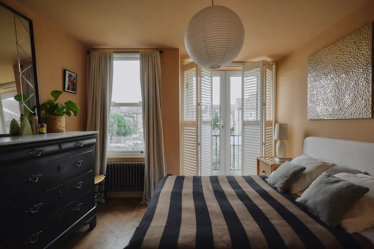 Modern Craftsmanship and Historic Charm in a London Home 16 bedroom color-drenched orange-pink walls striped bedding