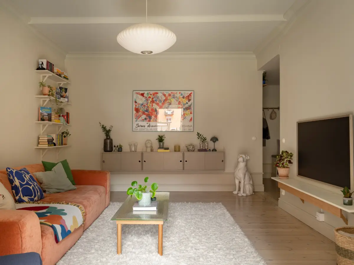 A Light Color Palette and a Charming Private Patio in a Stockholm Apartment 5 beige scandi living room orange sofa