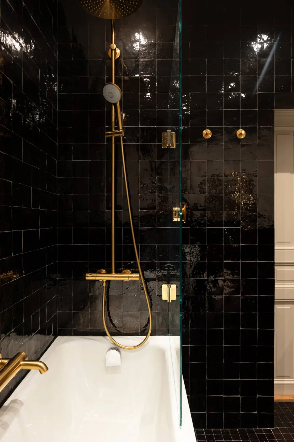 A Luxurious Family Apartment with a Dramatic Black Bathroom 30 black tiled bathroom brass fittings