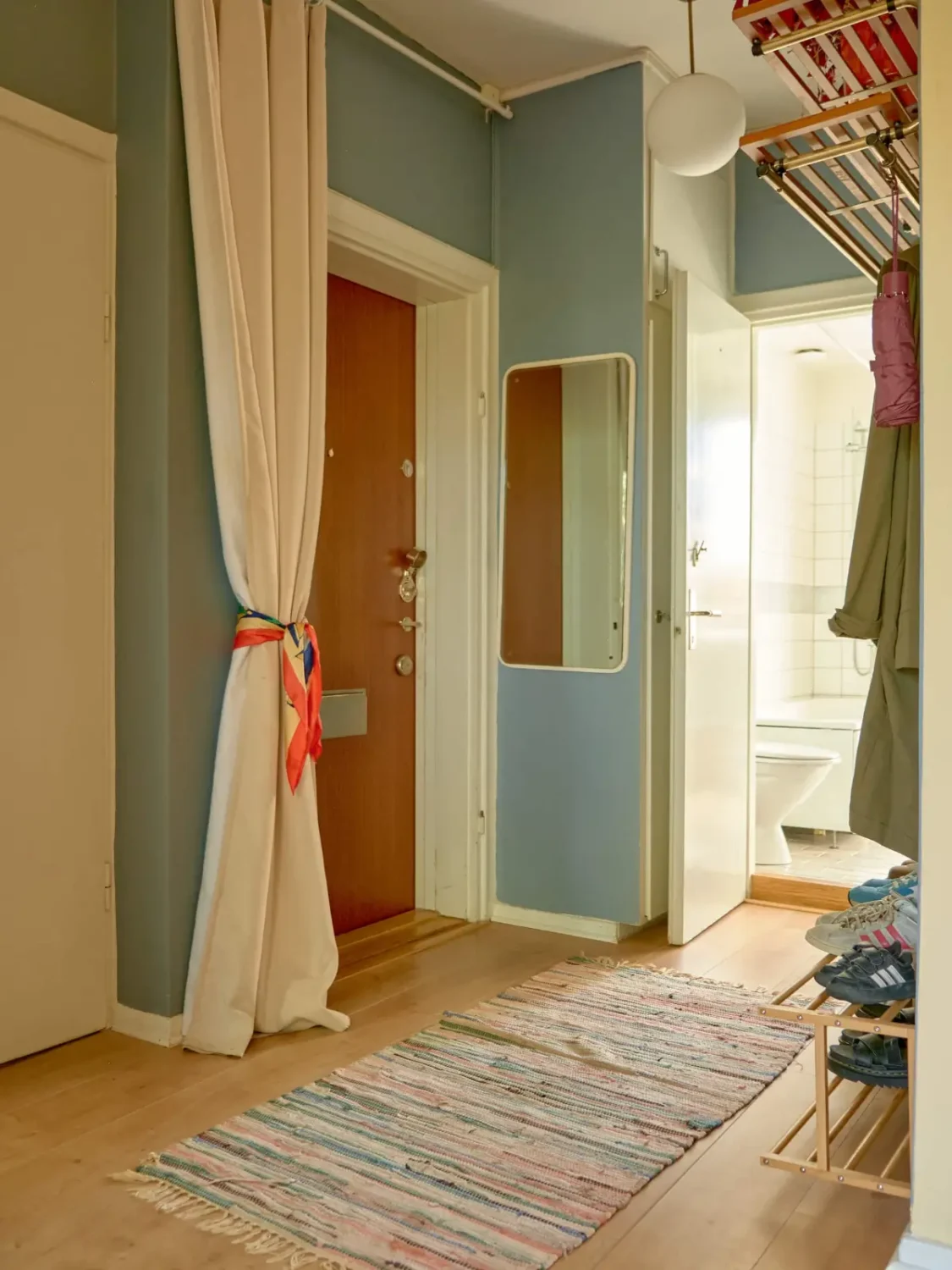 A Colorful and Cozy Midcentury Apartment in Stockholm 25 blue hall with curtain A Colorful and Cozy Midcentury Apartment in Stockholm