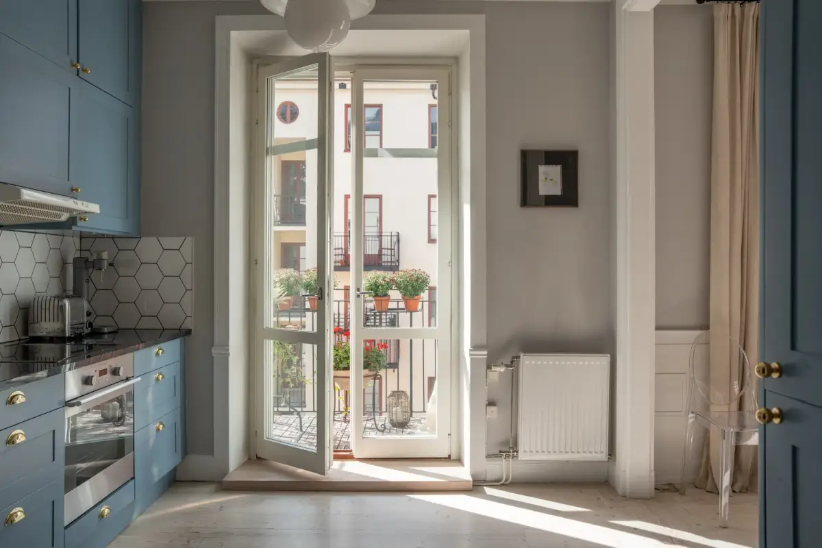 A Light Turn-of-the-Century Apartment with a Blue Kitchen 17 blue kitchen glass balcony doors