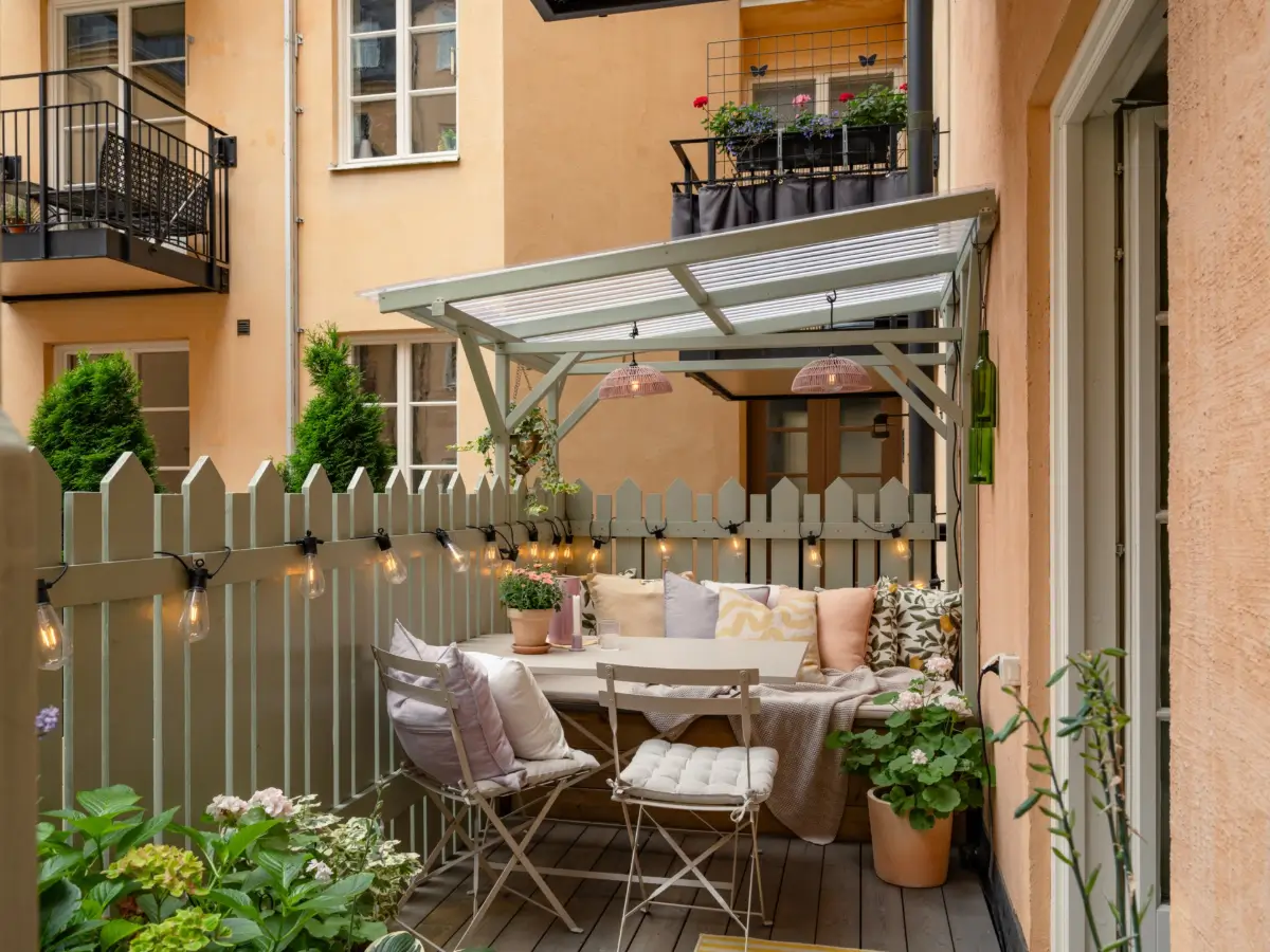 A Light Color Palette and a Charming Private Patio in a Stockholm Apartment 9 cozy terrace string lights