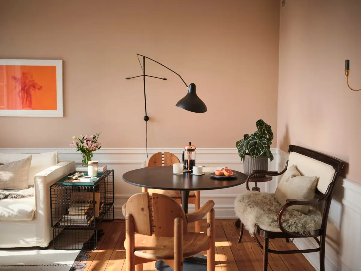 Warm Pink Walls and a Glass Room Divider in a Small Stockholm Apartment 6 dining nook black round table with bench nordroom