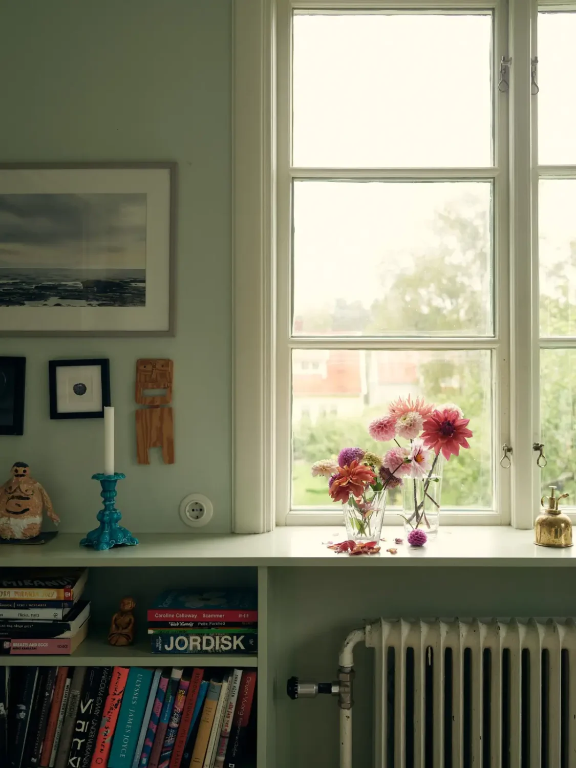 A Cheerful Color Palette in an Early 20th Century Villa in Stockholm 7 dining room window bookshelves