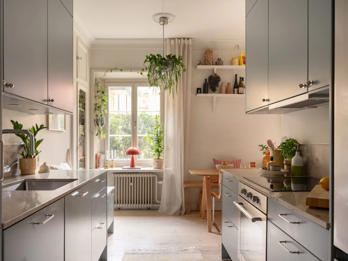 A Light Color Palette and a Charming Private Patio in a Stockholm Apartment 17 gray kitchen large window with plants
