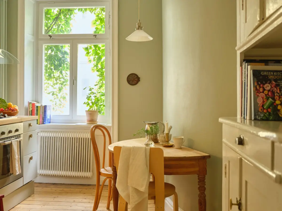 A Lush Balcony and Charming Rooms in a Late 19th Century Apartment 20 green kitchen walls small wooden table