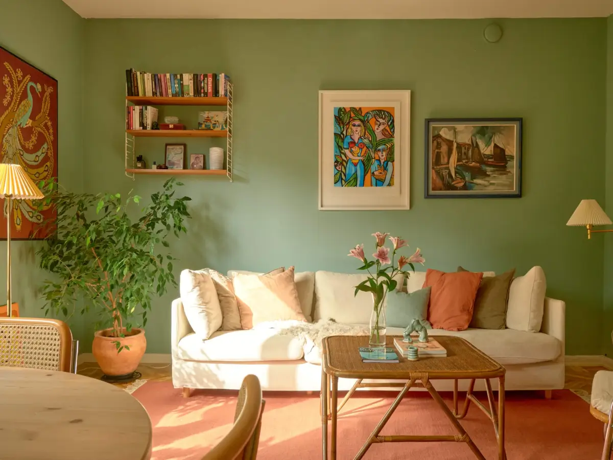 A Colorful and Cozy Midcentury Apartment in Stockholm 2 green living room white sofa pink rug
