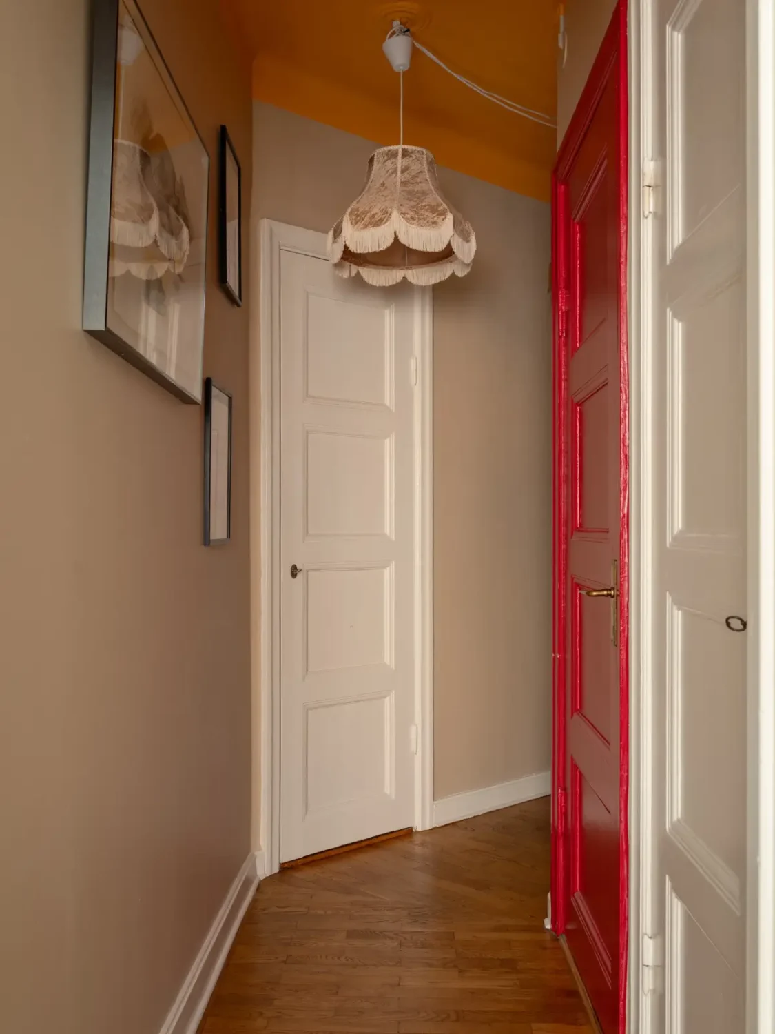 Warm Beige Walls and Practical Niches in a 1920s Studio Apartment 13 hall orange ceiling red-painted bathroom door