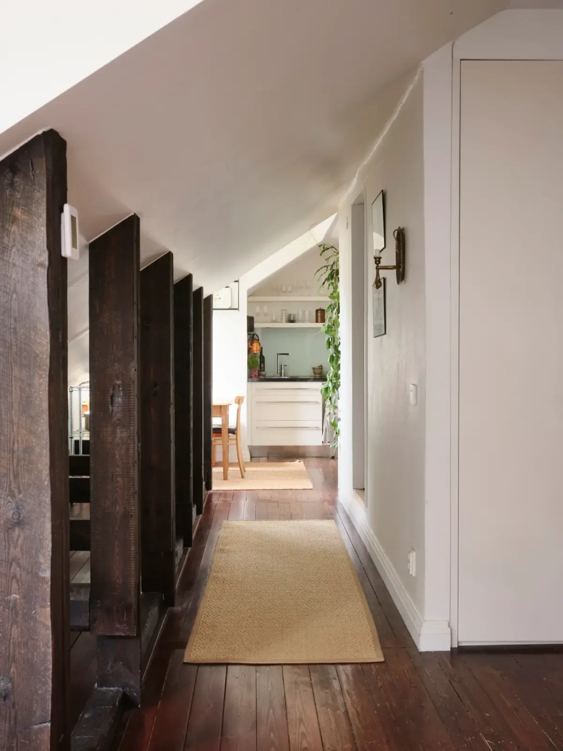 Exposed Beams and Dark-Stained Floorboards in a Cozy Attic Apartment 9 hall wooden beams