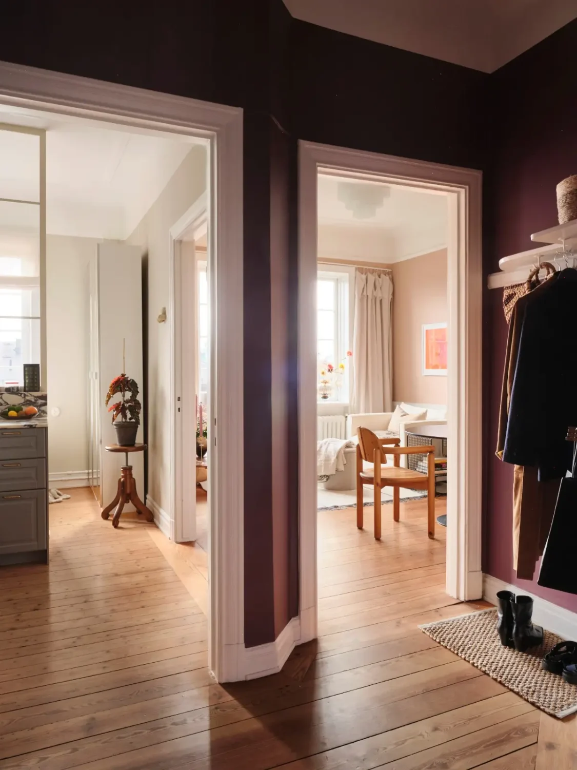 Warm Pink Walls and a Glass Room Divider in a Small Stockholm Apartment 26 hall wooden floor aubergine walls