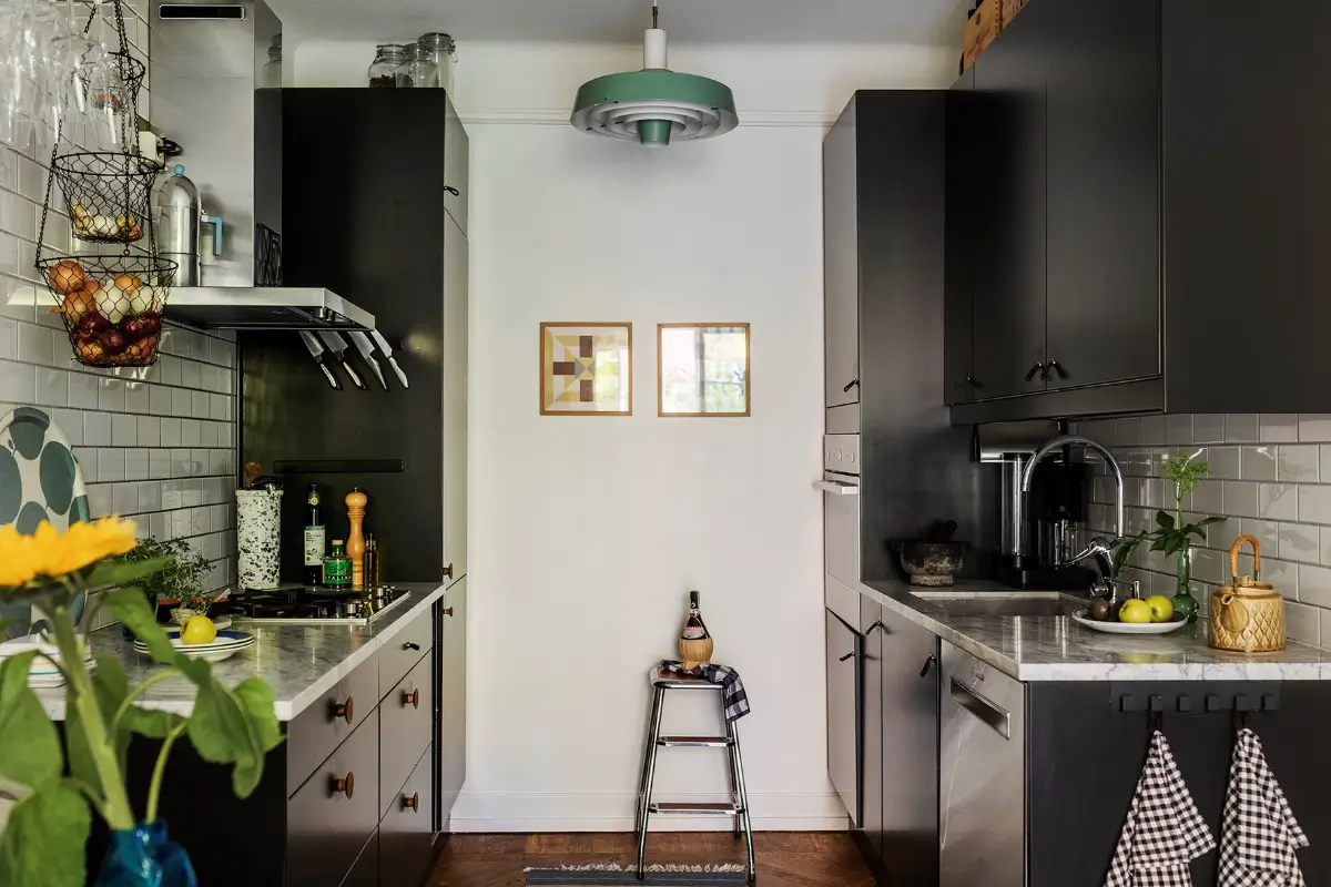 A Charming Swedish Courtyard Apartment Filled with Art 10 kitchen black cabinets marble worktop white backsplash tiles