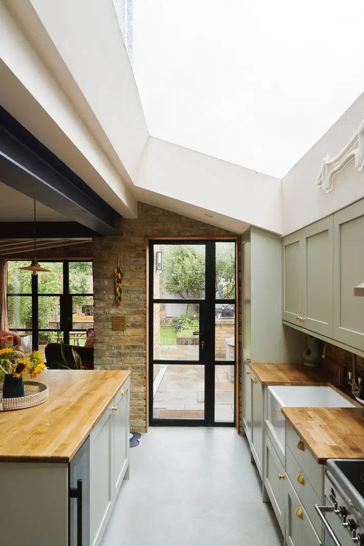 An Extended Victorian Apartment with Exposed Brick Walls 5 kitchen light green cabinets skylight