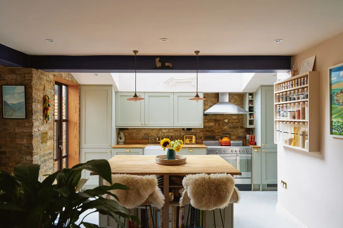 An Extended Victorian Apartment with Exposed Brick Walls 8 kitchen light sage green cabinets with island An Extended Victorian Apartment with Exposed Brick Walls