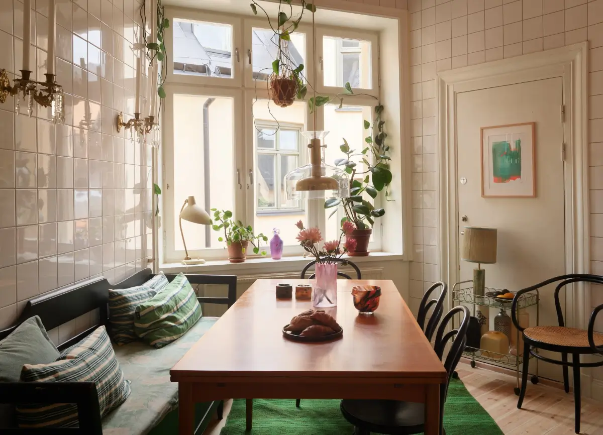 A Spacious Family Apartment with Original Details in Stockholm 18 kitchen table with bench white tiled walls