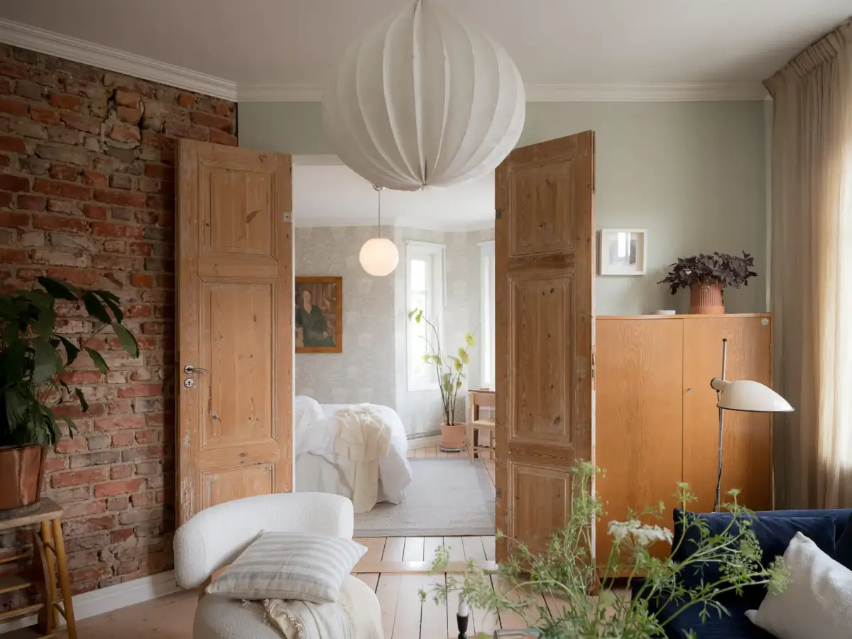 A Cozy Apartment with Exposed Brick and Period Details 8 living room double wooden doors exposed brick
