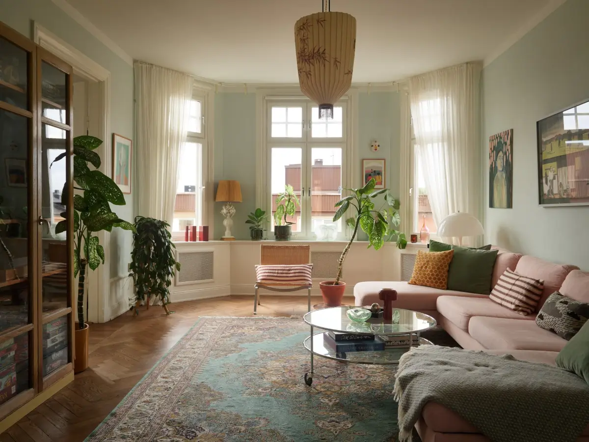A Spacious Family Apartment with Original Details in Stockholm 1 living room parquet floor large rug pink sofa bay window