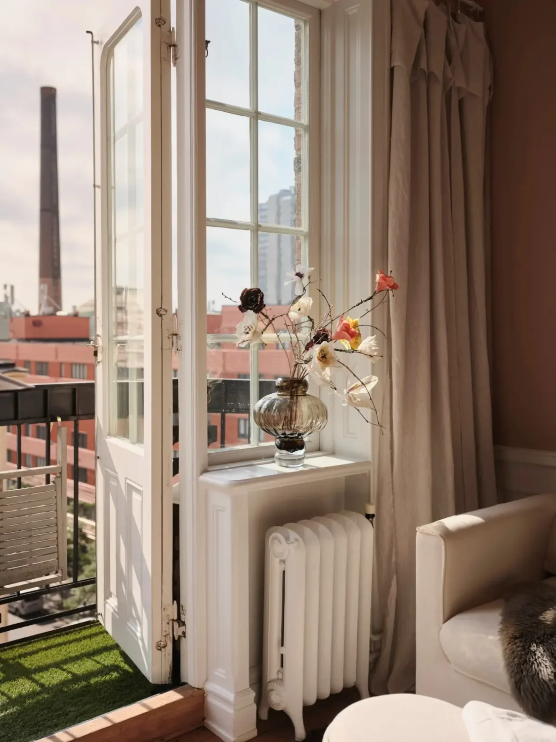 Warm Pink Walls and a Glass Room Divider in a Small Stockholm Apartment 11 living room window