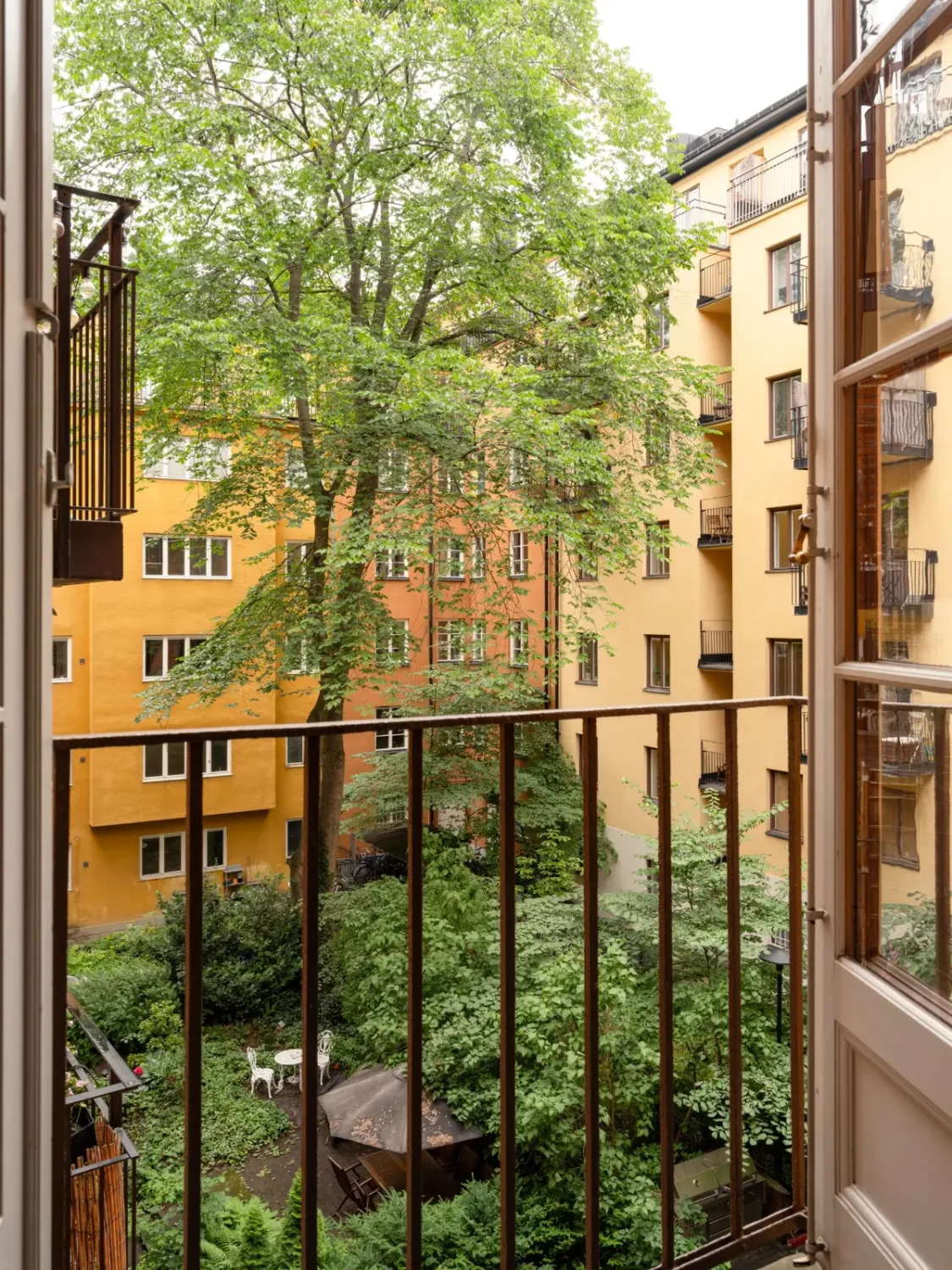 Warm Beige Walls and Practical Niches in a 1920s Studio Apartment 18 lush communal garden Warm Beige Walls and Practical Niches in a 1920s Studio Apartment