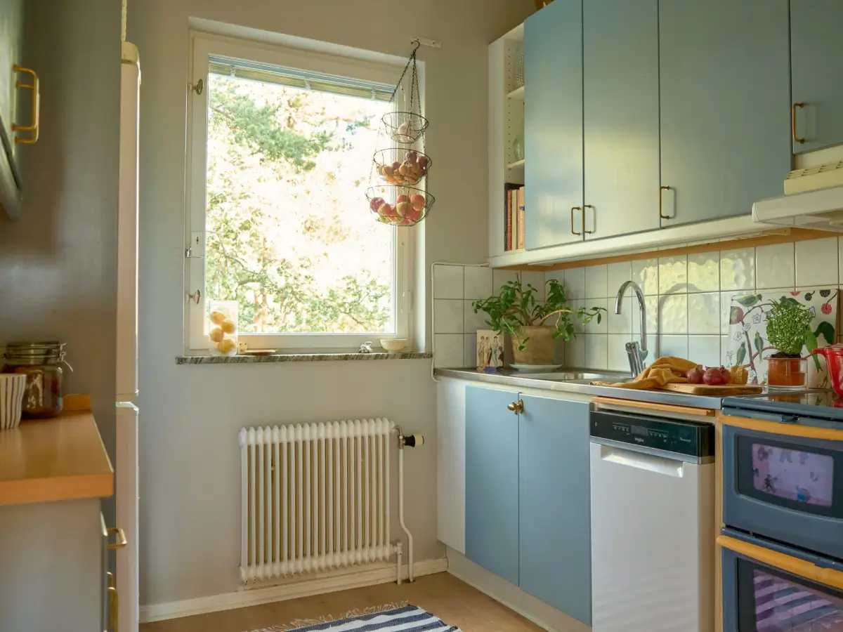 A Colorful and Cozy Midcentury Apartment in Stockholm 11 midcentury blue kitchen