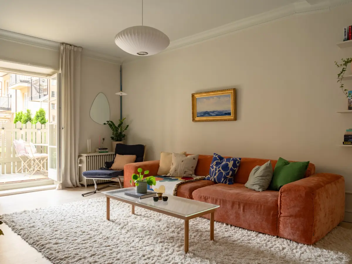 A Light Color Palette and a Charming Private Patio in a Stockholm Apartment 3 orange living room scandi living room