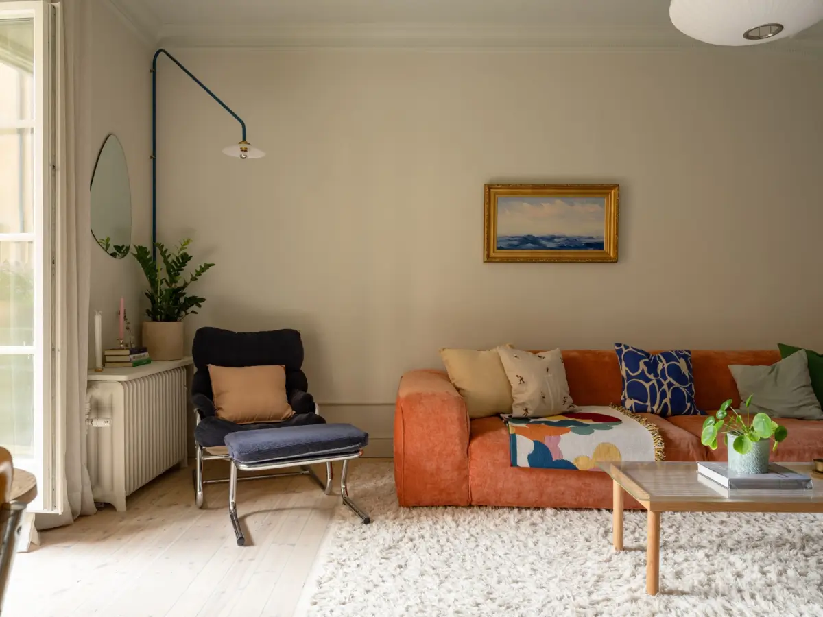 A Light Color Palette and a Charming Private Patio in a Stockholm Apartment 6 orange sofa blue chair