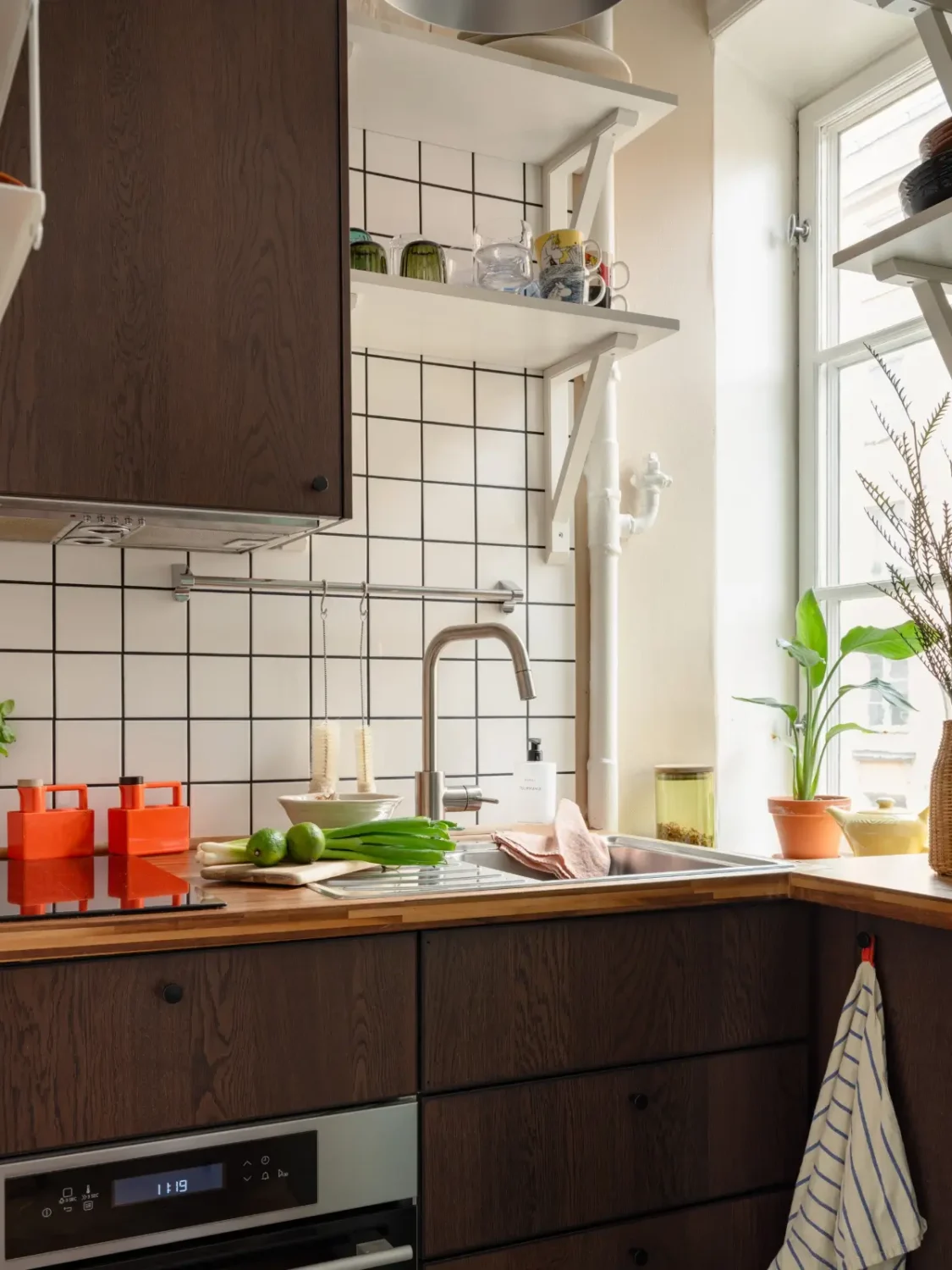 Warm Beige Walls and Practical Niches in a 1920s Studio Apartment 12 small kitchen walnut cabinets white tiles