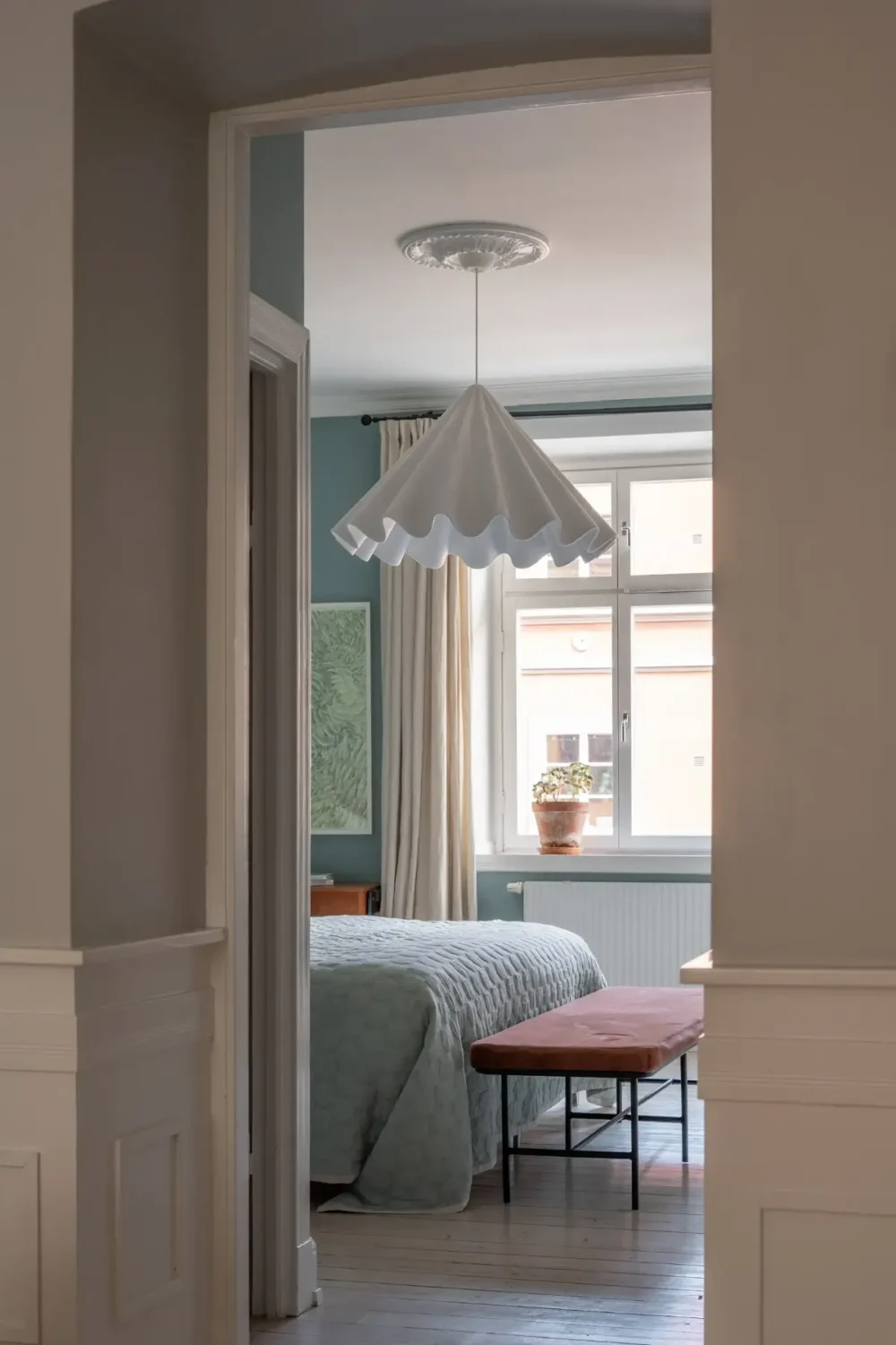 A Light Turn-of-the-Century Apartment with a Blue Kitchen 18 view into bedroom